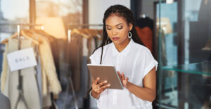 Retail store associate using a tablet to personalize in-store customer service in a boutique setting